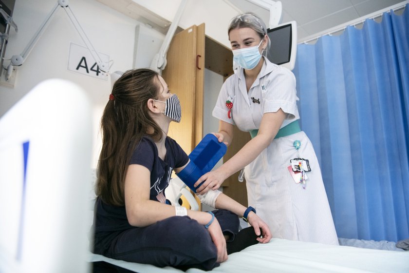 A nurse caring for a child in a hospital bed