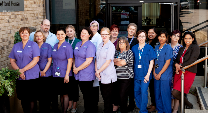 Team photo of staff at Cambridge IVF, taken outside Kefford House.