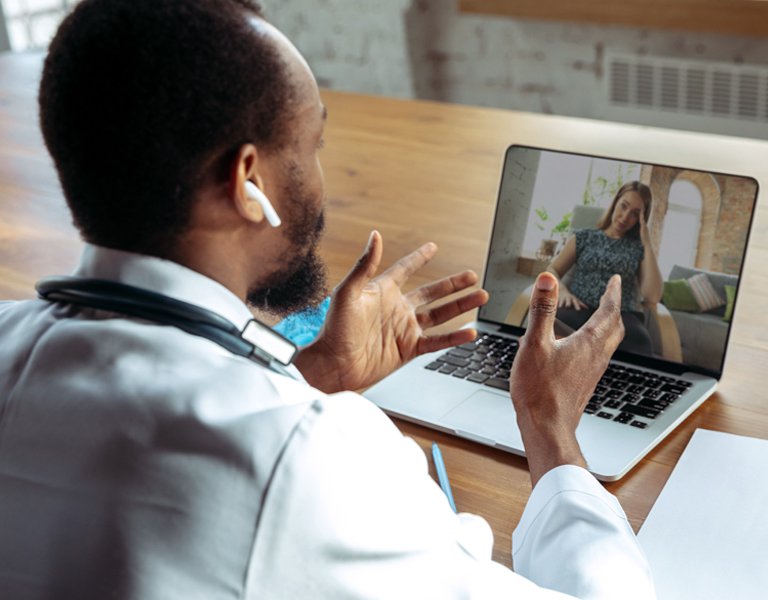 Patient having an online consultation with a doctor who is using a tablet.